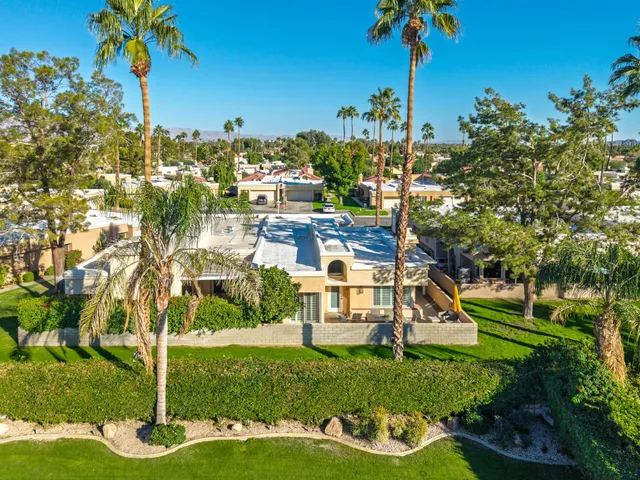 a view of a house with a yard and potted plants