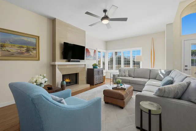 a living room with furniture a fireplace and a flat screen tv