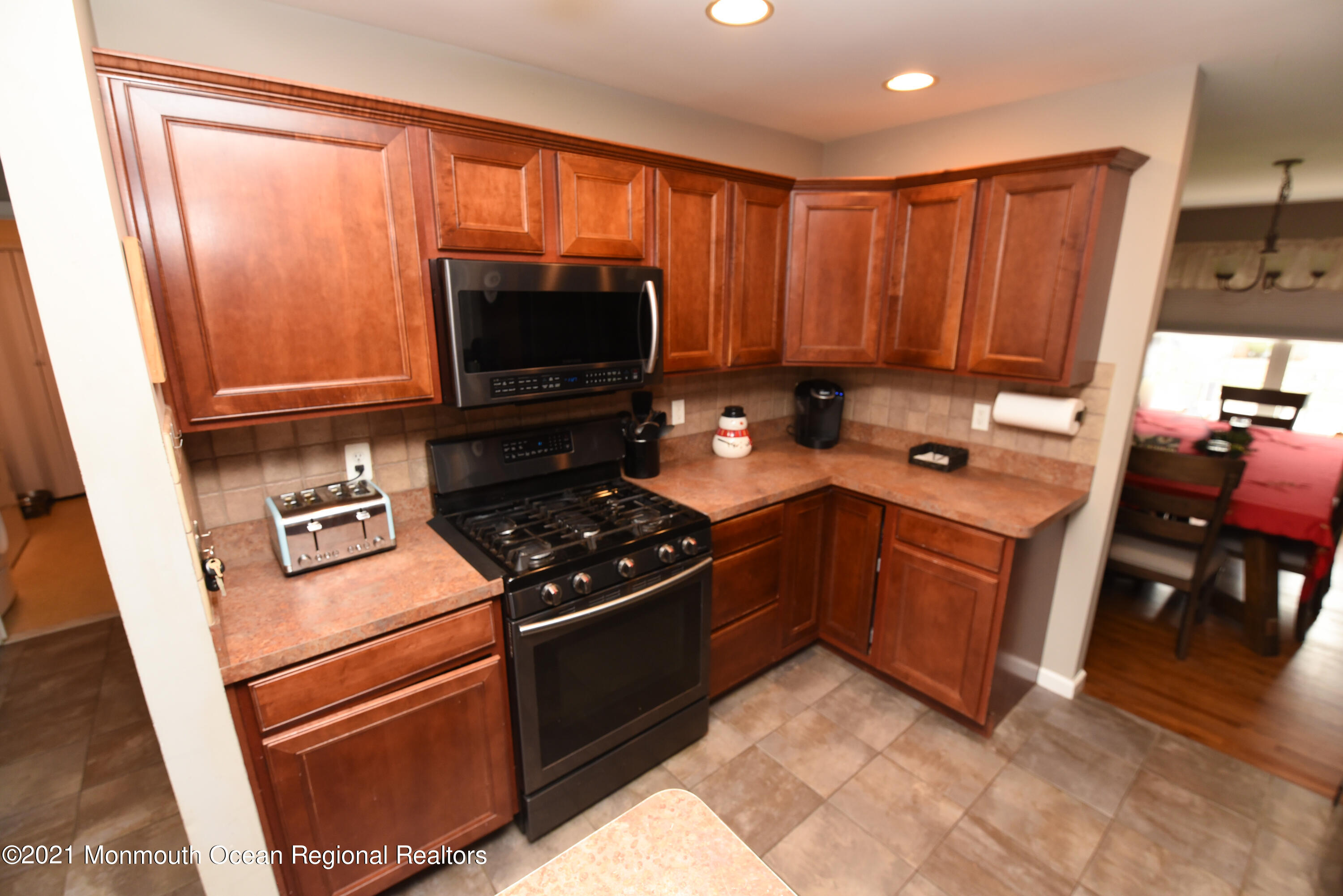 57 Mutineer Avenue Barnegat, NJ 08005 - Photo 25 of 89 a kitchen with a stove a microwave and wooden cabinets