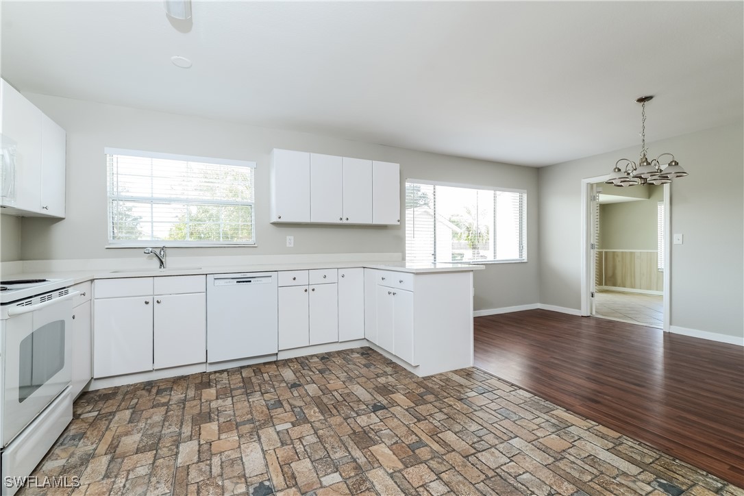 2809 Greendale Road North Port, FL 34287 - Photo 6 of 16 a kitchen with granite countertop a stove a sink and white cabinets