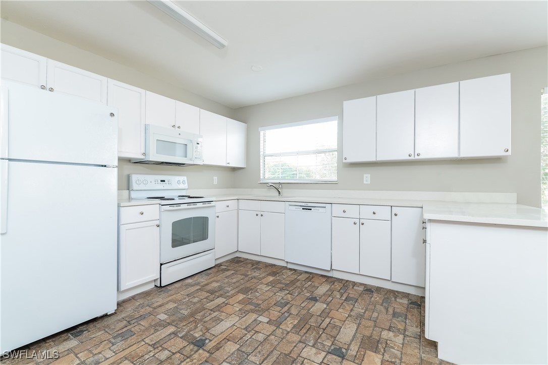 2809 Greendale Road North Port, FL 34287 - Photo 7 of 16 a kitchen with white cabinets and white appliances