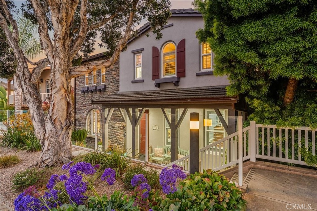 a front view of a house with a lot of flower plants