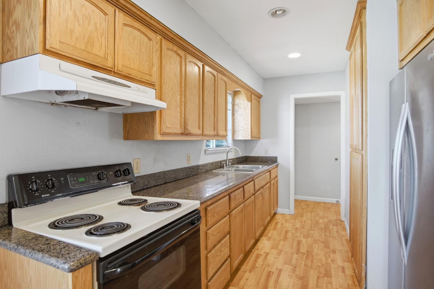 1409 Stonum Road Modesto, CA 95351 - Photo 21 of 40 a kitchen with a stove and a sink