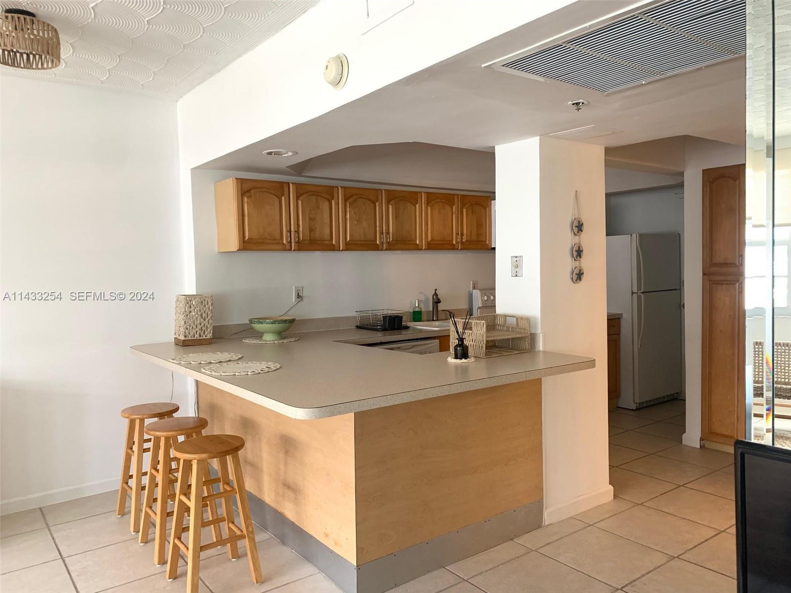 100 Lincoln Road, Unit 1039 Miami Beach, FL 33139 - Photo 10 of 26 a kitchen with stainless steel appliances granite countertop a sink and a refrigerator