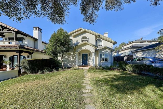 a view of a white house with a yard and plants