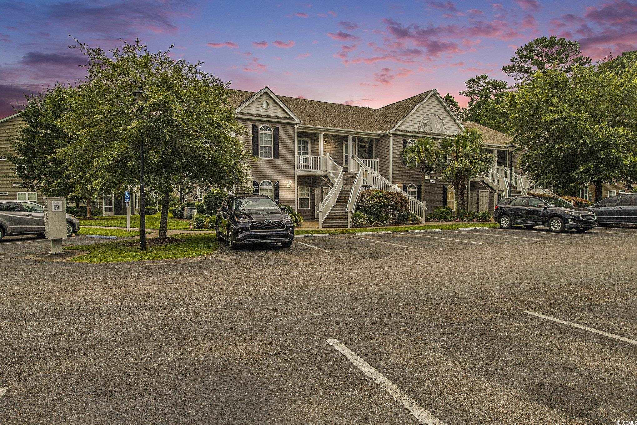 View of front of house featuring stairway, uncovered parking, and a porch