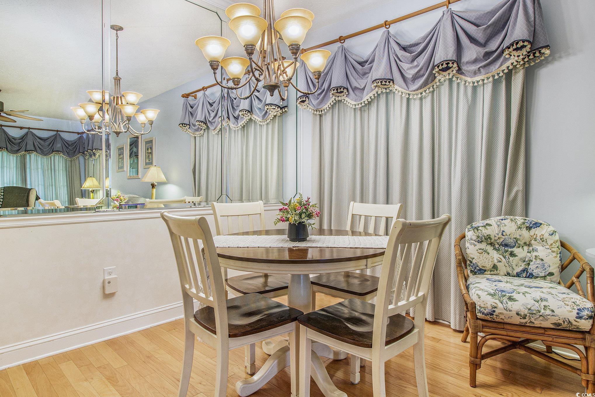 1141 Peace Pipe Place, Unit 101 Myrtle Beach, SC 29579 - Photo 13 of 28 Dining area featuring a chandelier, wood finished floors, and lofted ceiling