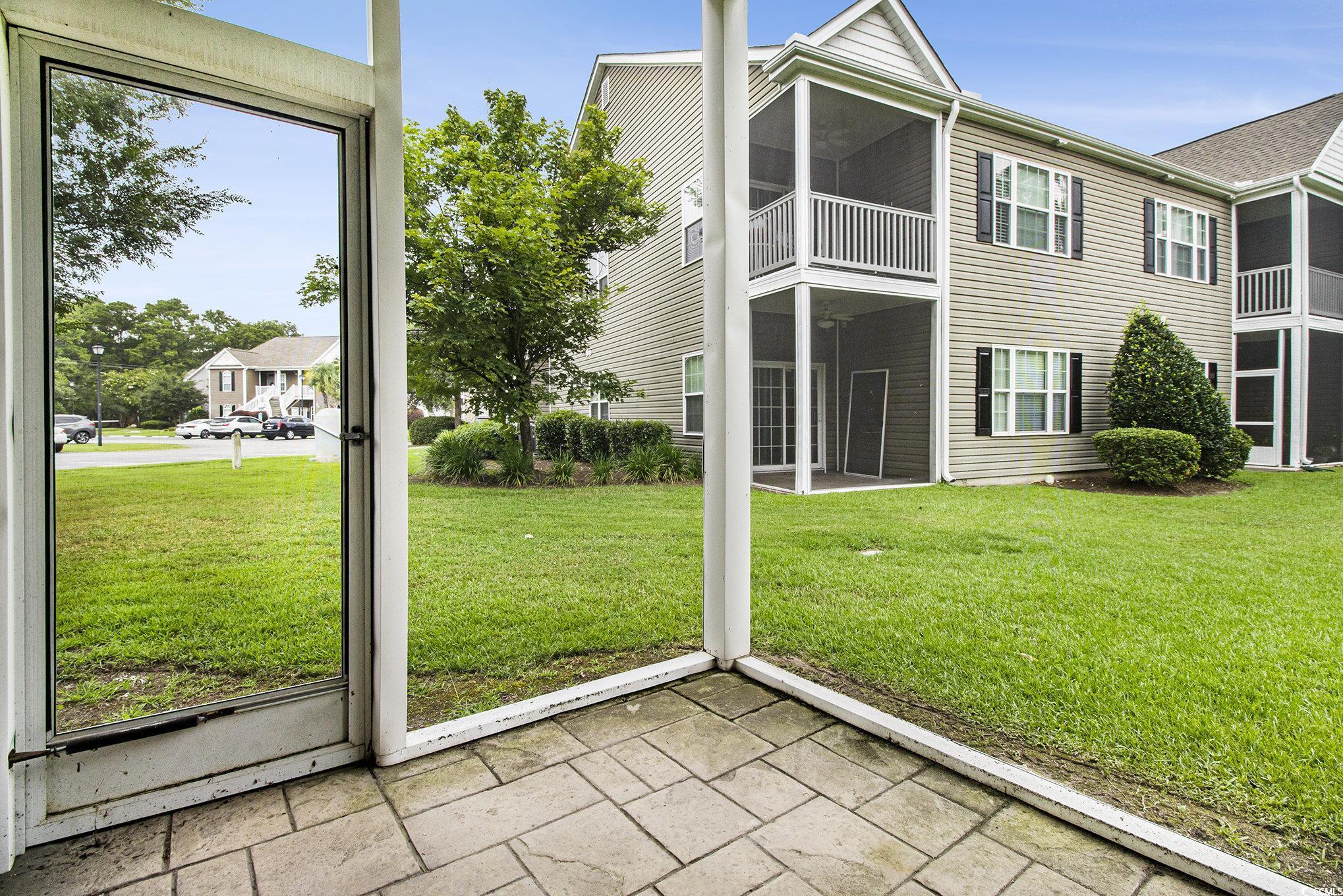 1141 Peace Pipe Place, Unit 101 Myrtle Beach, SC 29579 - Photo 25 of 28 Rear view of house featuring a lawn