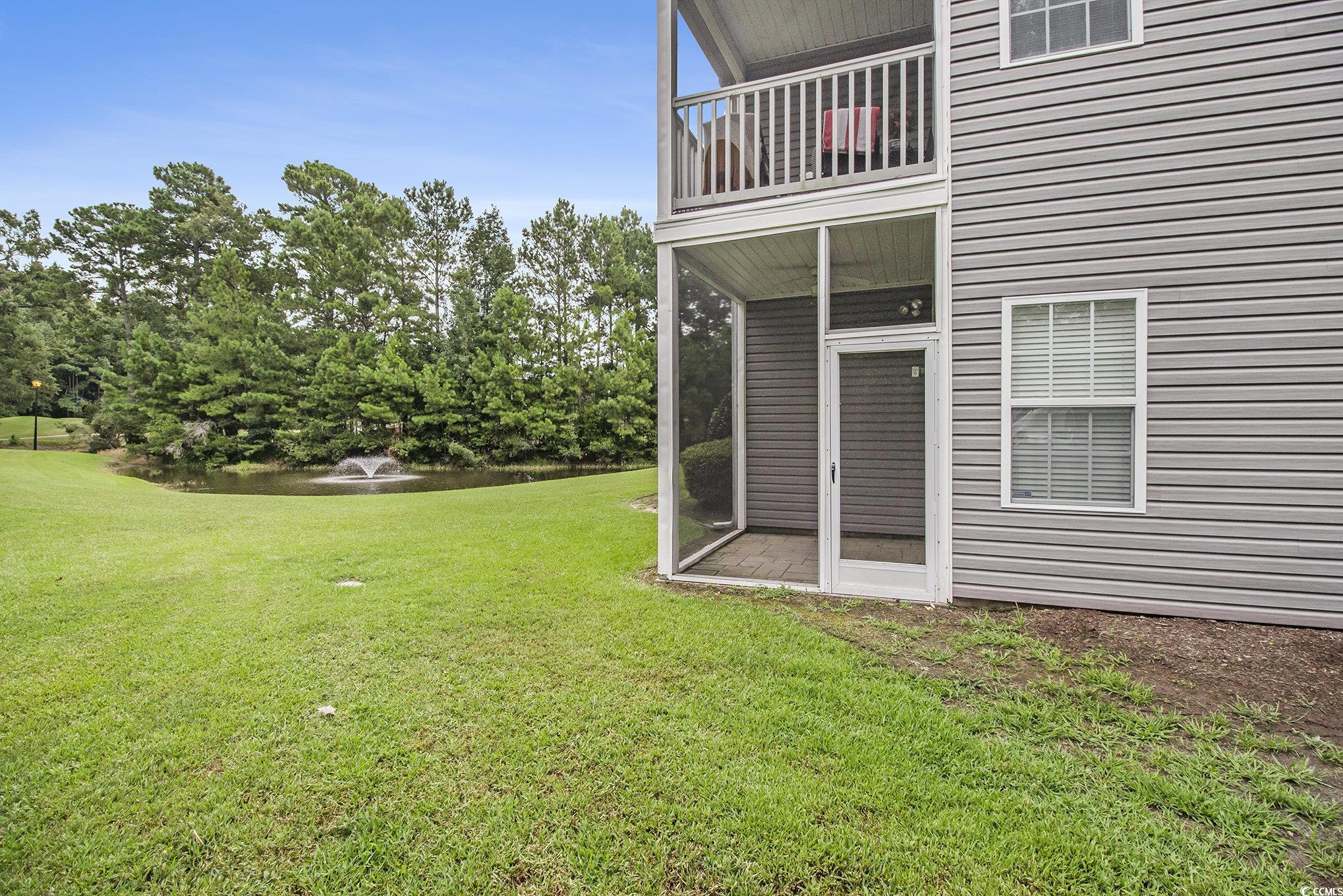 1141 Peace Pipe Place, Unit 101 Myrtle Beach, SC 29579 - Photo 26 of 28 View of green lawn with a balcony and view of scattered trees