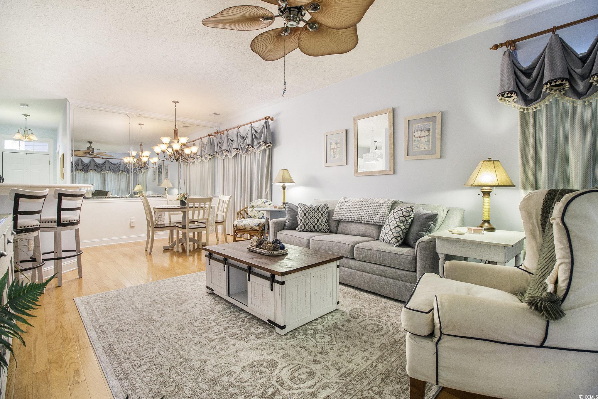 1141 Peace Pipe Place, Unit 101 Myrtle Beach, SC 29579 - Photo 7 of 28 Living area with a chandelier, ceiling fan, and light wood-type flooring