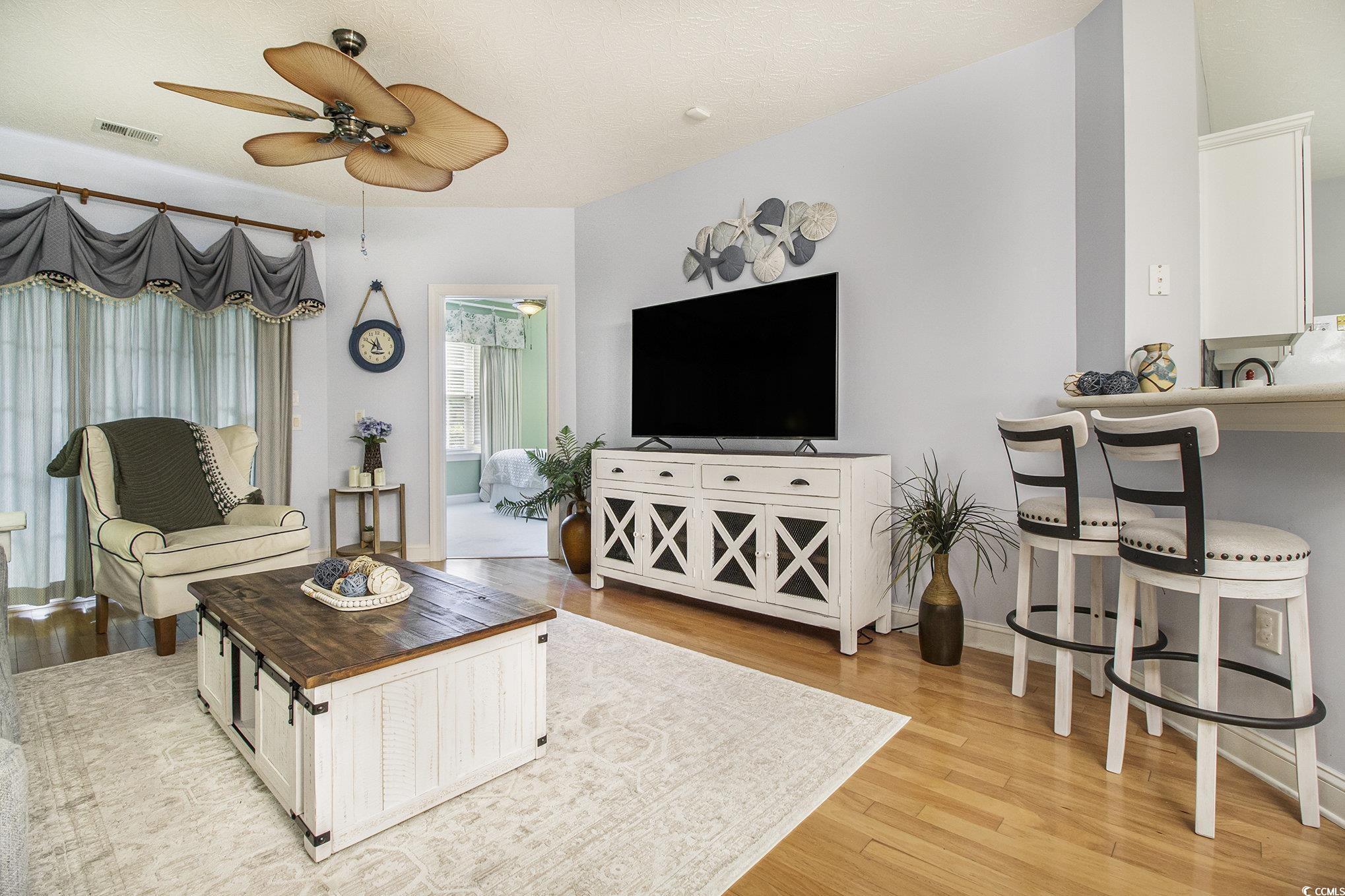 1141 Peace Pipe Place, Unit 101 Myrtle Beach, SC 29579 - Photo 9 of 28 Living room with a ceiling fan and light wood finished floors