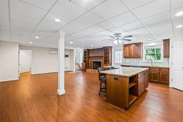a large kitchen with stainless steel appliances granite countertop a large stove a sink dishwasher and a oven with wooden floor