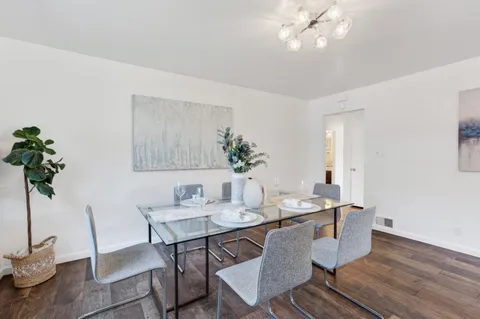 a dining room with furniture potted plants and wooden floor