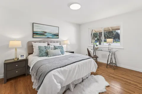 a bedroom with a bed a table and chair