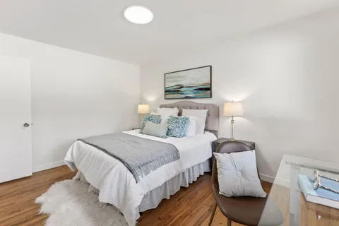 a bedroom with a bed and wooden floor