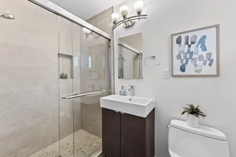 a bathroom with a toilet a sink and mirror