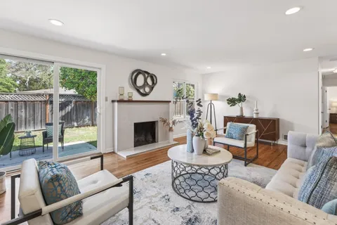 a living room with furniture a fireplace and a large window