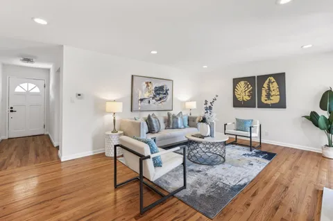 a living room with furniture and wooden floor