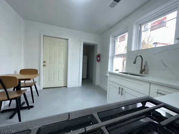 a kitchen with stainless steel appliances granite countertop a sink and a refrigerator