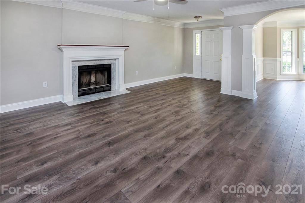 3518 Rindle Court Charlotte, NC 28269 - Photo 4 of 21 a view of an empty room with wooden floor fireplace and a window
