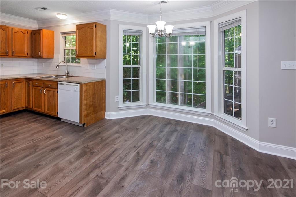 3518 Rindle Court Charlotte, NC 28269 - Photo 7 of 21 a view of a kitchen with a sink wooden cabinets and a window