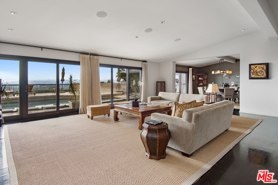 410 Walker Drive Beverly Hills, CA 90210 - Photo 12 of 36 a living room with furniture a large window and chandelier