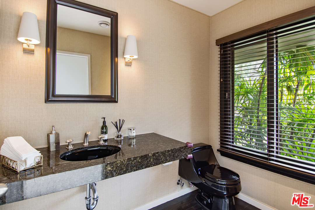 410 Walker Drive Beverly Hills, CA 90210 - Photo 15 of 36 a bathroom with a granite countertop sink and a mirror