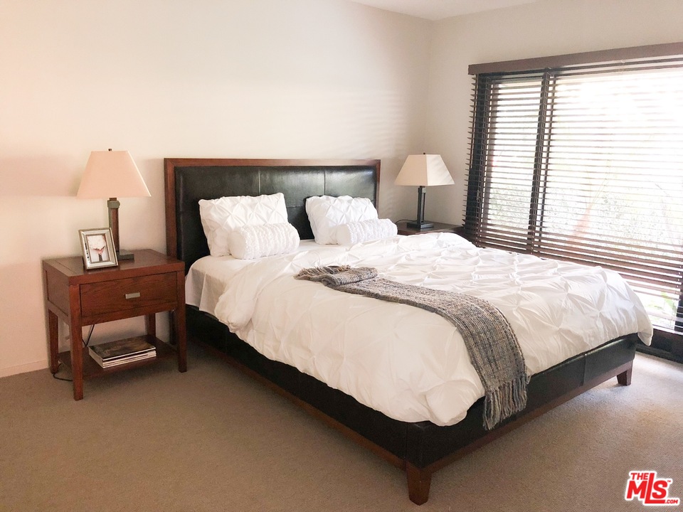 410 Walker Drive Beverly Hills, CA 90210 - Photo 19 of 36 a bed sitting in a bedroom next to a window