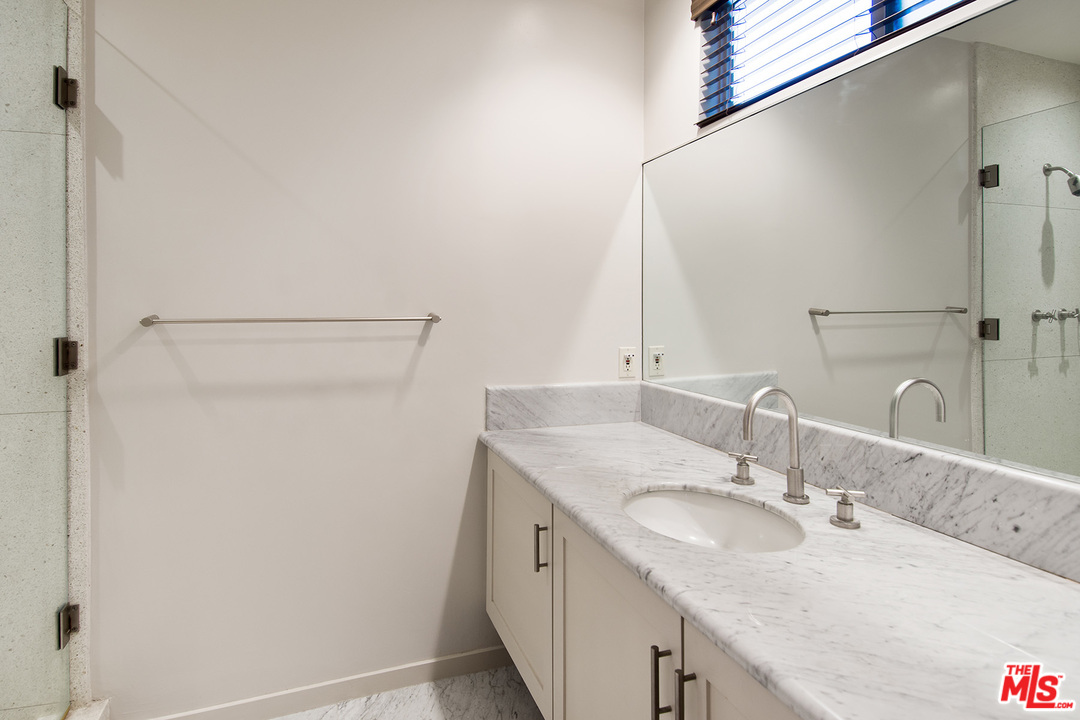 410 Walker Drive Beverly Hills, CA 90210 - Photo 20 of 36 a bathroom with a granite countertop sink and a mirror