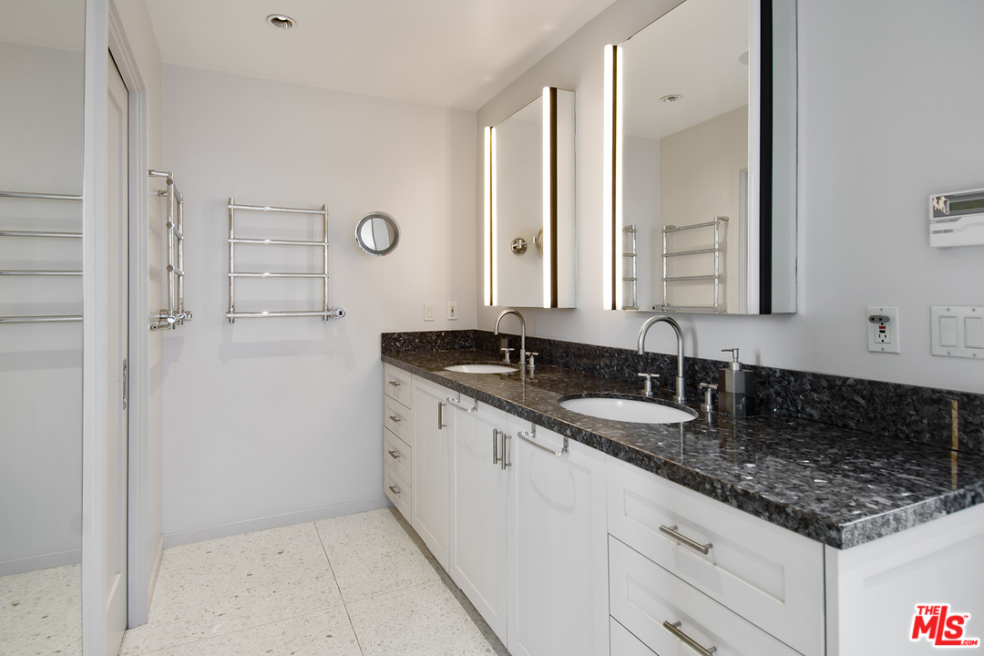 410 Walker Drive Beverly Hills, CA 90210 - Photo 23 of 36 a bathroom with a granite countertop sink and a mirror