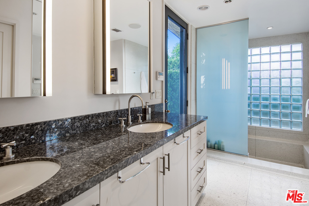 410 Walker Drive Beverly Hills, CA 90210 - Photo 24 of 36 a bathroom with a granite countertop sink and a mirror
