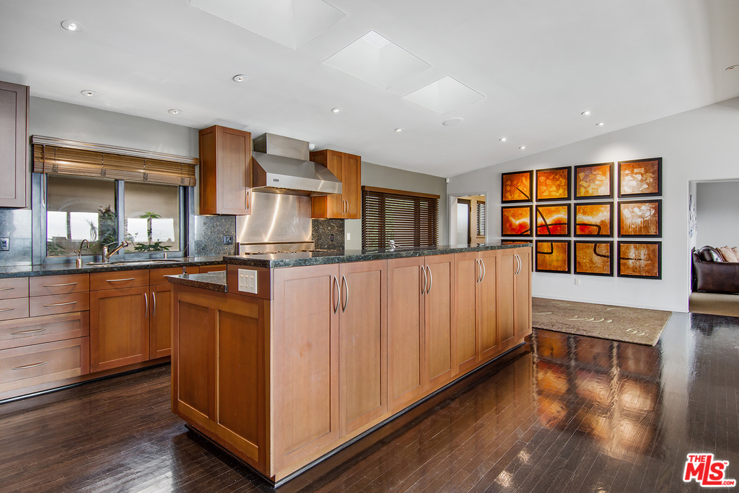 410 Walker Drive Beverly Hills, CA 90210 - Photo 9 of 36 a kitchen with stainless steel appliances granite countertop a refrigerator and a wooden cabinets