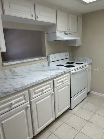 a stove top oven sitting inside of a kitchen