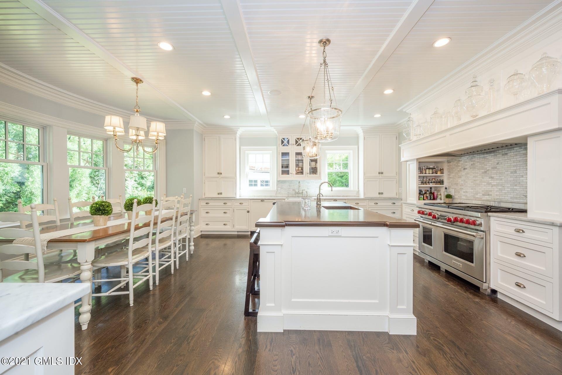 45 Willow Road Riverside, CT 06878 - Photo 11 of 38 a kitchen with stainless steel appliances a stove a sink a island a stove and white cabinets with wooden floor