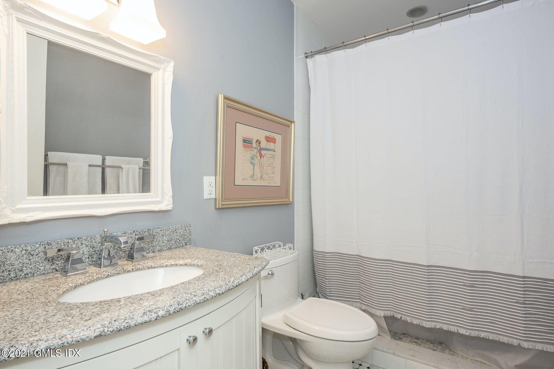 45 Willow Road Riverside, CT 06878 - Photo 35 of 38 a bathroom with a granite countertop sink toilet and a mirror