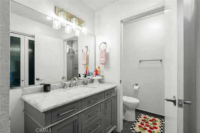 a bathroom with a sink a toilet and a mirror