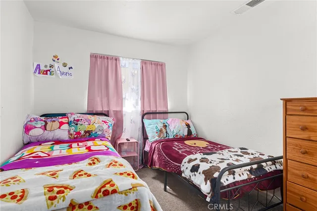 a bedroom with two beds and a baby crib