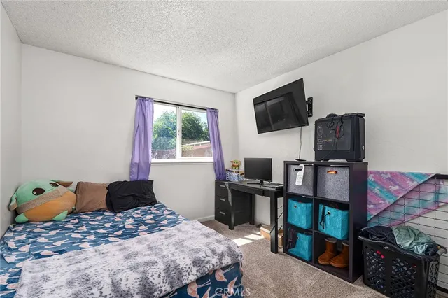 a bedroom with a bed and flat screen tv