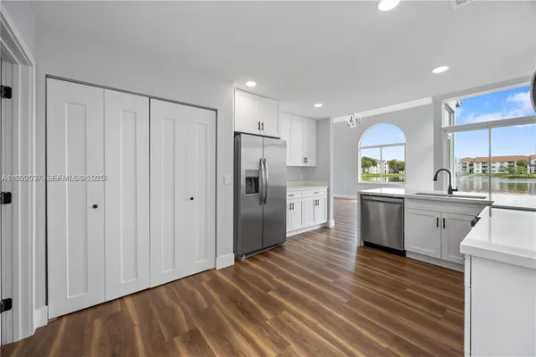 a kitchen with stainless steel appliances a refrigerator sink and cabinets