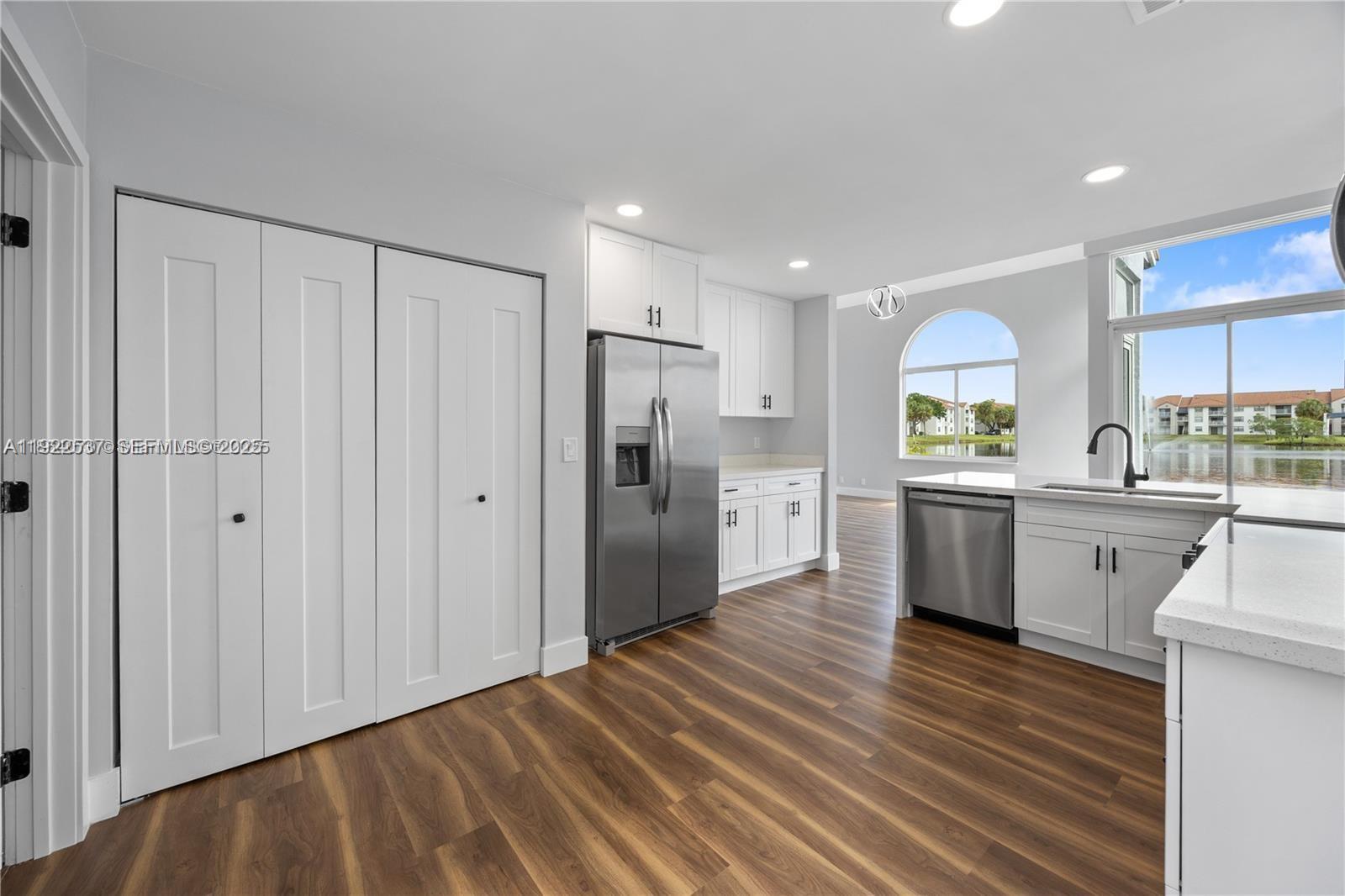 3835 Lombardy Street Hollywood, FL 33021 - Photo 12 of 25 a kitchen with stainless steel appliances a refrigerator sink and cabinets