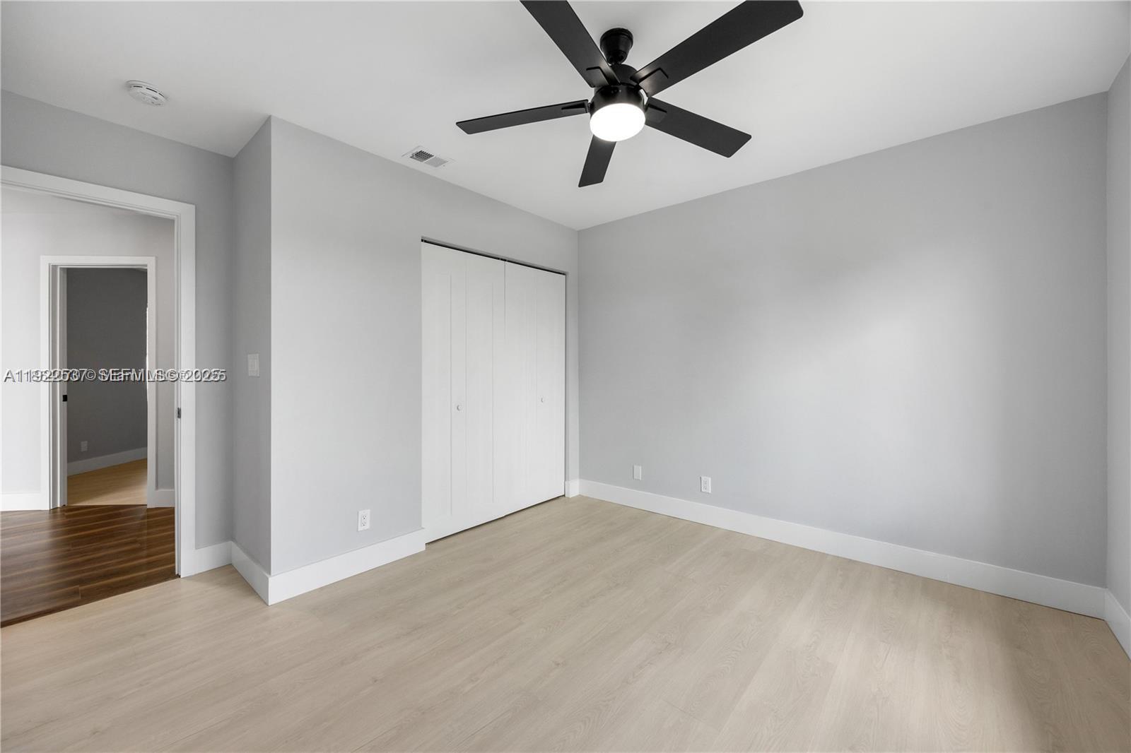 3835 Lombardy Street Hollywood, FL 33021 - Photo 20 of 25 an empty room with wooden floor and a ceiling fan