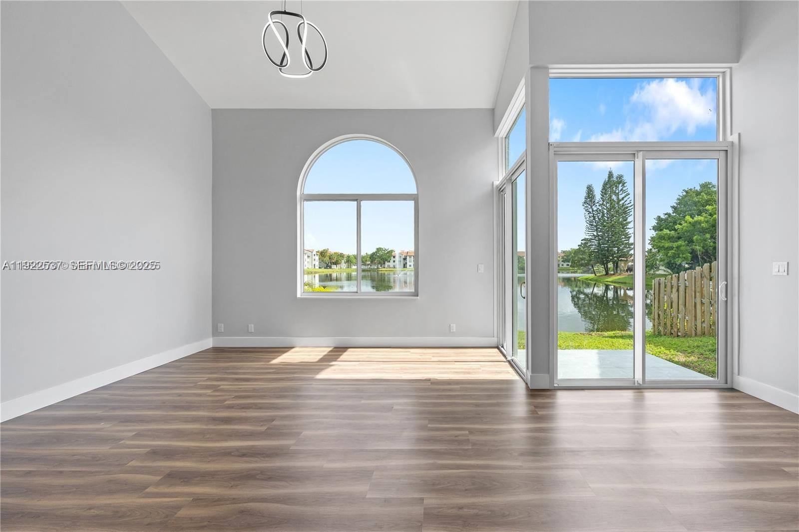 3835 Lombardy Street Hollywood, FL 33021 - Photo 2 of 25 a view of an empty room with a window and wooden floor