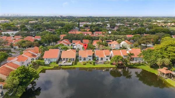 an aerial view of residential houses with outdoor space and lake view