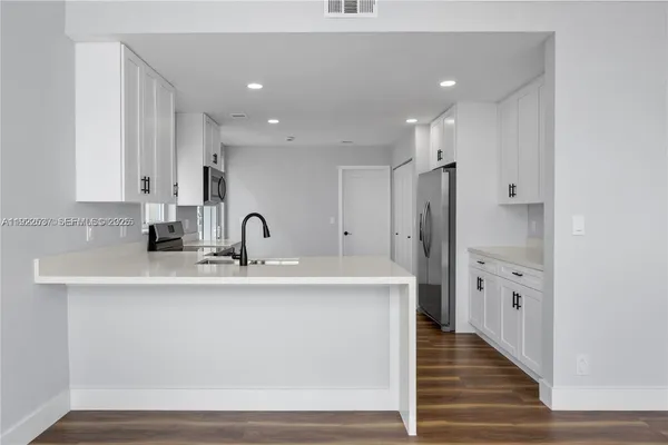 a view of a kitchen with white cabinets