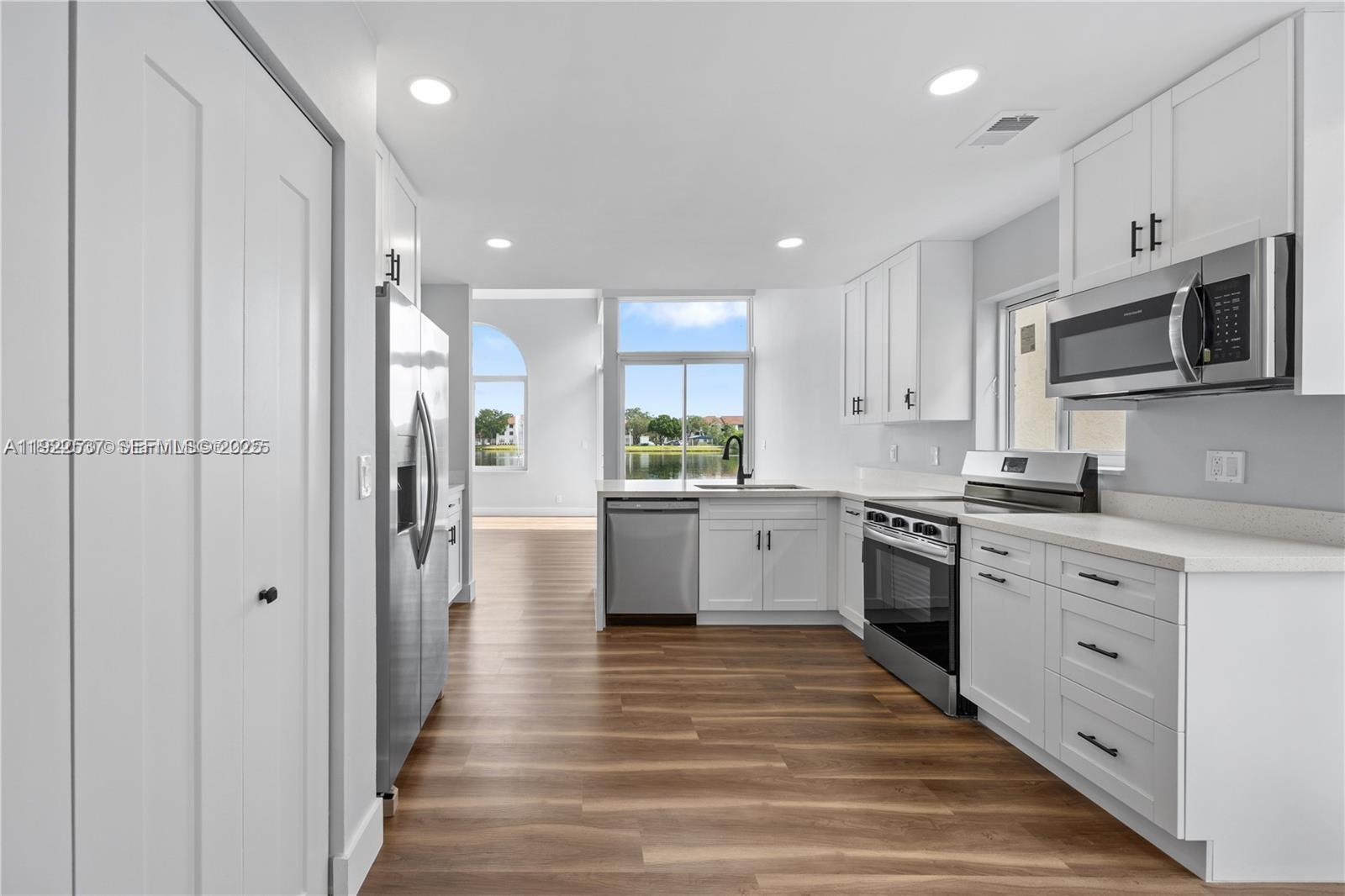 3835 Lombardy Street Hollywood, FL 33021 - Photo 9 of 25 a kitchen with stainless steel appliances kitchen island granite countertop a refrigerator and a stove top oven