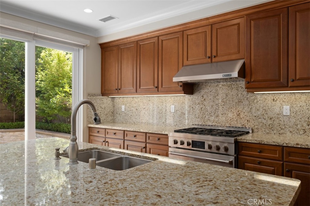 61 Triana Irvine, CA 92618 - Photo 13 of 56 a kitchen with stainless steel appliances granite countertop a stove a sink and a microwave