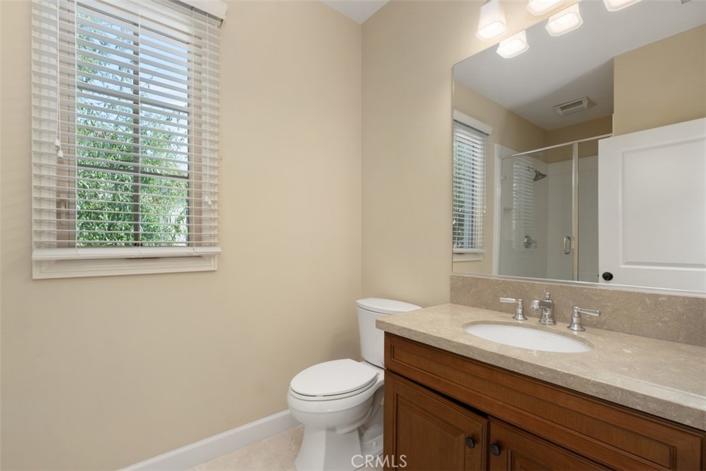 61 Triana Irvine, CA 92618 - Photo 30 of 56 a bathroom with a granite countertop sink toilet and a mirror
