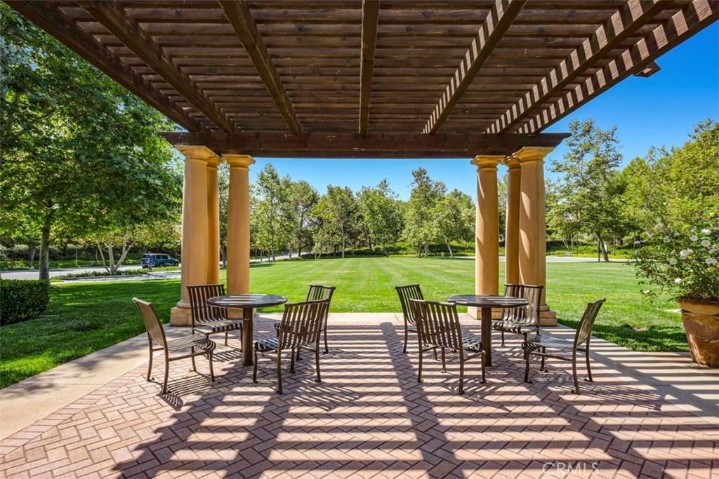 61 Triana Irvine, CA 92618 - Photo 55 of 56 a view of a patio with table and chairs potted plants and palm trees