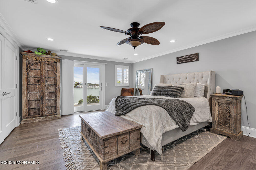 2547 River Road Manasquan, NJ 08736 - Photo 39 of 75 a bedroom with a large bed a flat tv screen and dresser