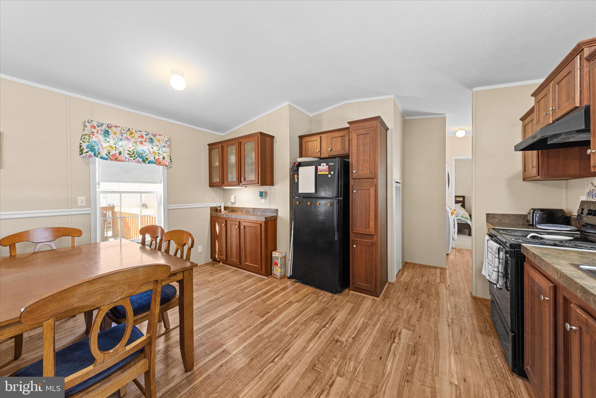 33461 Daisy Street Lewes, DE 19958 - Photo 16 of 42 a kitchen with stainless steel appliances granite countertop a refrigerator a stove top oven a sink dishwasher and wooden cabinets with wooden floor